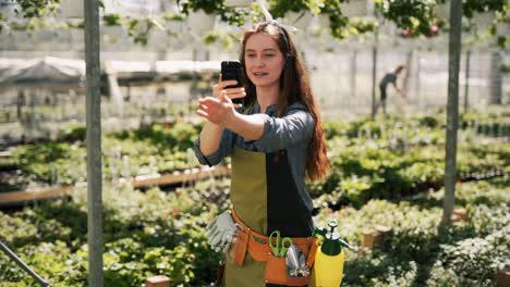 Redhead-woman-gardener-with-smartphone-shoots-video-and-tells