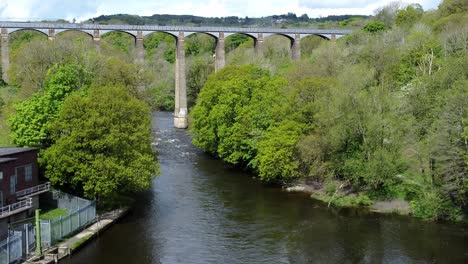 Aerial-view-Pontcysyllte-aqueduct-and-River-Dee-canal-narrow-boat-bride-in-Chirk-Welsh-valley-countryside-slow-push-in