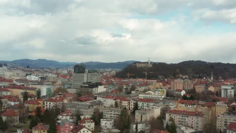 Aerial-shot-slowly-pulling-up-over-the-capital-of-Slovenia,-Ljubljana-on-a-cloudy-day