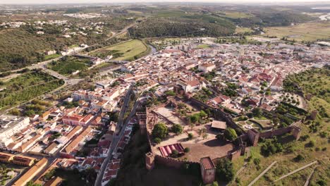 Fortified-walled-city-of-Silves,-ancient-capital-of-Algarve-in-Portugal---Aerial-forward-panoramic-view