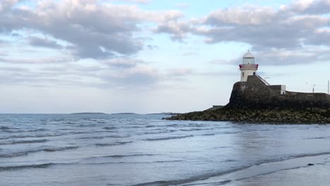 Tiny-waves-hitting-the-beach-with-Skerries-Lighthouse-visible-in-the-background