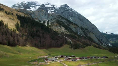 Aerial-drone-flight-at-scenic-Ahornboden-mountain-valley-above-Engtal-village-along-the-Rissach-river-with-fresh-blue-water-in-the-Bavarian-Austrian-alps-on-a-cloudy-and-sunny-day