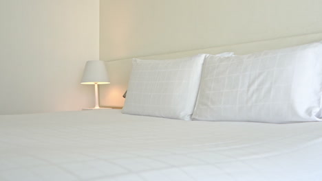 Doppelbett-Mit-Weißem-Kopfteil-Und-Offener-Bettwäsche-Und-Kissen-Im-Hotelzimmer