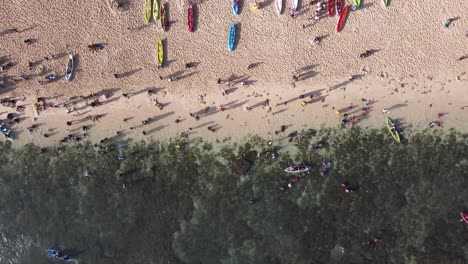 Aerial-view,-activities-of-holiday-tourists-on-Sadranan-beach,-Gunung-Kidul,-Yogyakarta-using-canoes-and-swimming