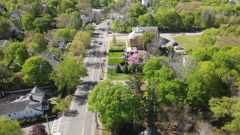 Aerial-static-footage-of-tree-lined-street-with-traffic,-spring-foliage,-Hingham-MA