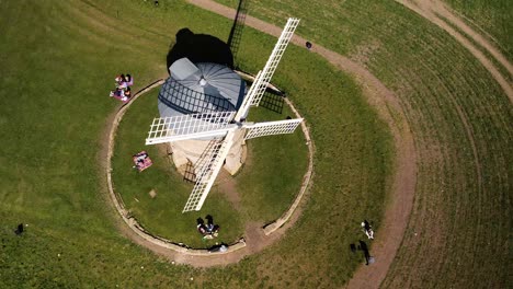 Landmark-Chesterton-historic-wooden-sail-windmill-aerial-orbit-birdseye-left-view-above-tourists-in-rural-English-countryside