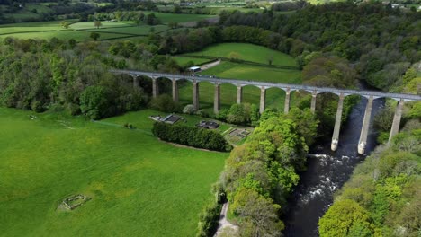 Aerial-view-Pontcysyllte-aqueduct-and-River-Dee-canal-narrow-boat-bride-in-Chirk-Welsh-valley-countryside-pull-back-pan-right