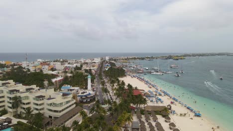 Aerial-ascending-view-of-Isla-Mujeres-town-and-seashore-in-Yucatan,-Mexico