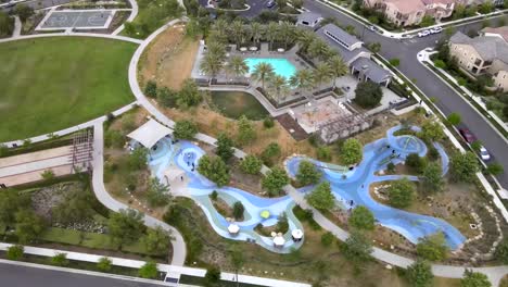 Aerial-view-above-colorful-winding-Tustin-public-skate-park-playground-paths-play-area-walkways-orbit-right