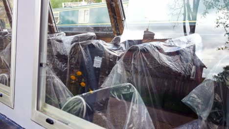 Plastic-bag-covered-seating-on-tourist-barge-boat-waiting-empty-on-British-canal-during-Covid-pandemic