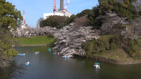 Slow-pan-across-beautiful-Chidorigafuchi-Moat-with-colorful-rowboats-on-clear-blue-sky-day