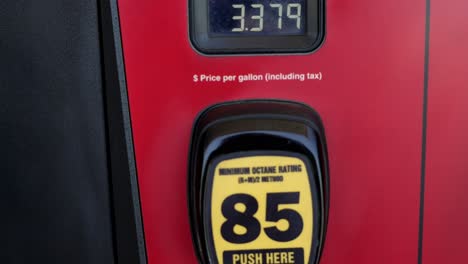 Red-and-black-gas-pumps-with-prices-super-high-over-three-dollars,-panning-top-to-bottom-to-show-unleaded,-regular-grade-fuel-prices-at-3