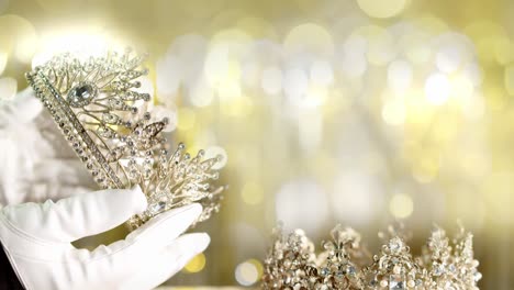 Eine-Schönheitswettbewerb-Diamantkrone-Wird-Auf-Fehler-überprüft,-Um-Sie-An-Die-Miss-Schönheitskönigin-Zu-Vergeben---Unscharfer-Goldener-Bokeh-Hintergrund
