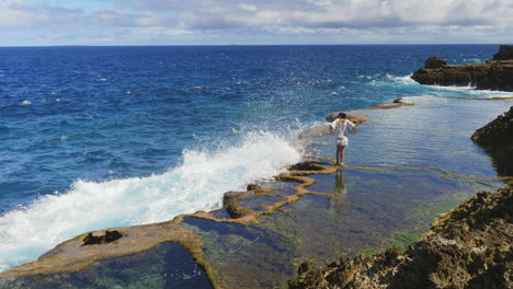 Coastal-natural-rock-pools,-female-tourist-on-Cap-des-pins,-Lifou,-New-Caledonia
