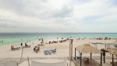 Tropical-Seascape-With-People-Enjoying-The-Beautiful-Beach-And-Sand-Of-Playa-Indios-in-Isla-Mujeres,-Mexico---wide-shot