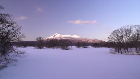 Slow-pan-across-beautiful-frozen-lake-and-alpine-glow-mountain-at-Onuma-Koen-in-Hokkaido