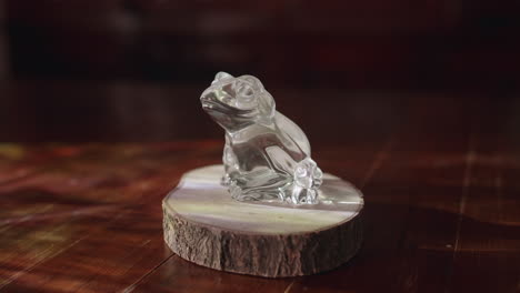 Small-crystal-frog-ornament-sitting-on-a-fake-log