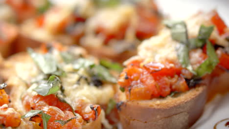Bread-toasts-with-cheese,-tomato-and-basil,-close-up,-Mediterranean
