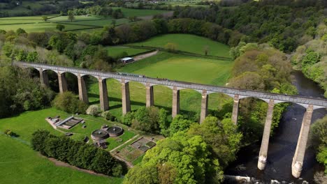 Aerial-view-Pontcysyllte-aqueduct-and-River-Dee-canal-narrow-boat-bride-in-Chirk-Welsh-valley-countryside-rising-pull-back