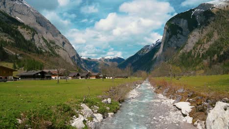 Idyllic-Ahornboden-mountain-canyon-river-Rissach-with-fresh-blue-water-flowing-down-green-lush-fields-in-the-Bavarian-Austrian-alps-at-Engtal