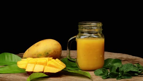 stop-motion-mango-juice-smoothie-in-glass-jar,-black-background
