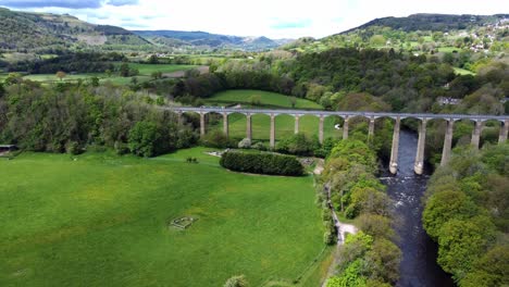 Aerial-view-Pontcysyllte-aqueduct-and-River-Dee-canal-narrow-boat-bride-in-Chirk-Welsh-valley-countryside-descending-tilt-up-reveal