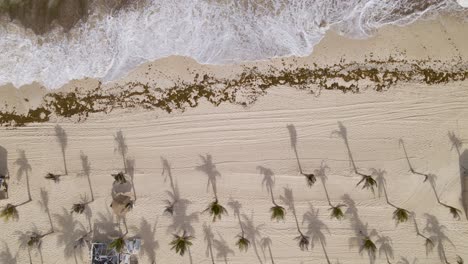 Aerial-View-of-ocean-waves-washing-up-on-sandy-beach-in-Cancun-Mexico,Pull-Back-Shot