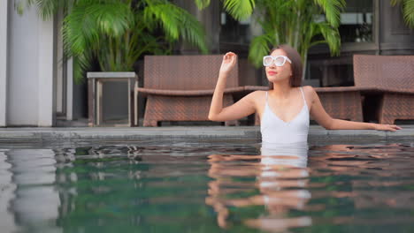 A-pretty-woman-relaxes-in-a-resort-swimming-pool
