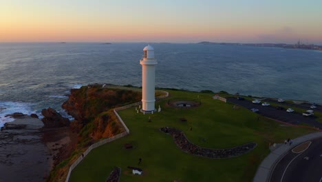 Wollongong-Head-Lighthouse-At-Sunset-In-Sydney,-New-South-Wales,-Australia---aerial-drone-shot