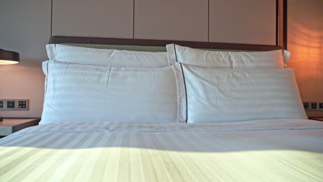 Close-up-pan-of-pillows-on-a-hotel-bed