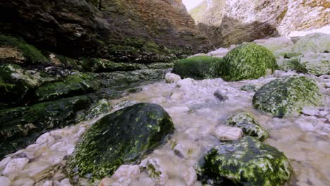stunning-stream-with-moss-covered-rocks-at-the-seaside-in-england