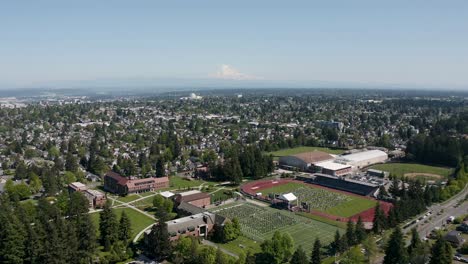 Vista-Aérea-De-Los-Edificios-De-La-Ciudad-Y-La-Ceremonia-De-Graduación-En-El-Campo-De-La-Universidad-De-Puget-Sound-En-Tacoma,-Washington