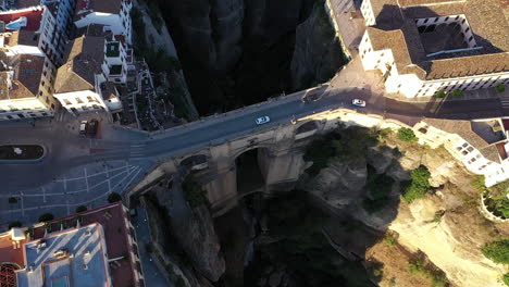 AERIAL---Flying-over-town-of-Ronda,-Malaga,-Spain,-wide-tilt-up-backwards-reveal