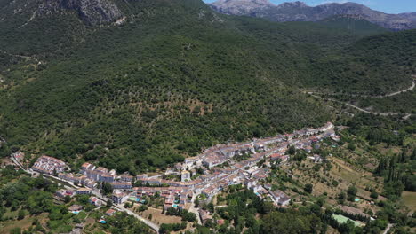 AERIAL---The-village-of-Grazalema-in-Cadiz,-Andalusia,-Spain,-lowering-wide-shot