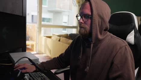 COMPUTERS---Man-in-a-hoodie-uses-mouse-while-surfing-the-internet,-medium-shot