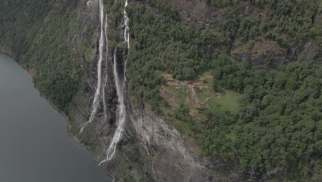 Slow-aerial-circular-shot-around-the-seven-sisters-waterfall-and-Knivsflå-farm,-Geiranger-fjord