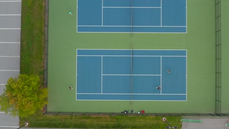 Aerial-of-people-playing-doubles-tennis-on-court