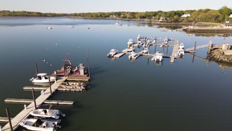 Aerial-pull-back-shot-of-stationary-boats-docked-in-Hingham-Harbor-south-of-Boston-during-the-day