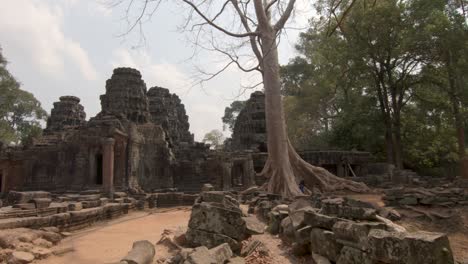 Pan-shot-showing-the-ancient-temples-of-AngkorWat-in-Cambodia,-showing-stones-ruins-and-temples,-blue-sky-day