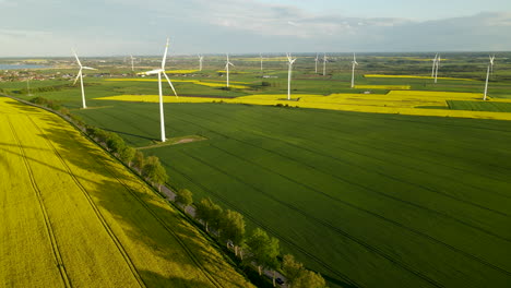 Wind-turbine-park-with-green-and-yellow-farm-land-in-Poland,-aerial