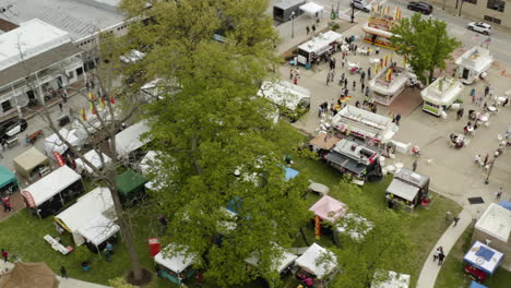 AERIAL---Dogwood-Festival-people-and-booths,-Siloam-Springs,-AR,-truck-left
