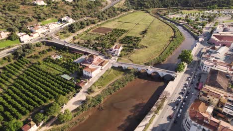 Rotating-aerial-of-Ponte-Velha,-the-monumental-arched-bridge-in-Silves,-Portugal