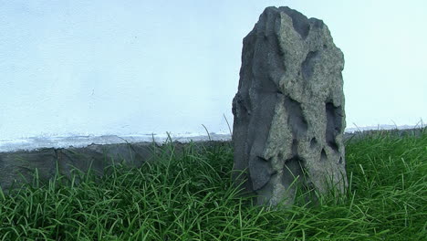 Ein-Dekorativer-Felsen-In-Einem-Japanischen-Garten-Mit-Einer-Weißen-Stuckwand-Im-Hintergrund