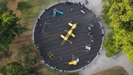 Aerial-top-down-view-of-children-enjoying-swings-and-slides-in-the-outdoor-park