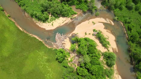 Descending-spiral-shot-of-drying-riverbed-with-a-natural-dam