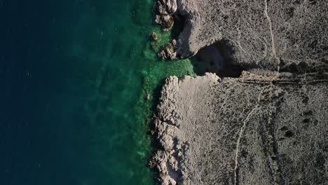 Aerial-shot-with-movement-straight-and-down-shot-to-the-coast-of-luka-great-contrast-of-colors-in-4k-adriatic-sea-and-rocky-mountain