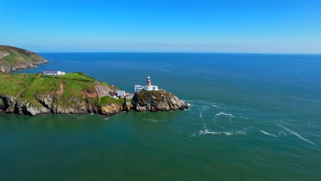 Aerial-view-of-a-lighthouse-revealing-rocky-coast-and-peninsula