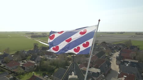 Bandera-De-La-Provincia-De-Frisia-Ondeando-En-El-Viento-En-La-Parte-Superior-De-La-Torre-De-La-Iglesia-En-El-Pueblo