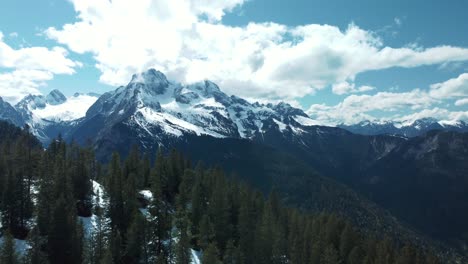 Wide-epic-mountain-panorama-ascend-at-scenic-Schachen-near-Bavaria-Elmau-castle-and-snowy-glacier-peaks-in-the-alps-on-a-cloudy-and-sunny-day-along-trees,-rocks,-forest-and-hills-in-nature