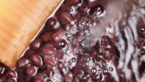 Close-up-view-of-water-adding-into-cooked-red-beans